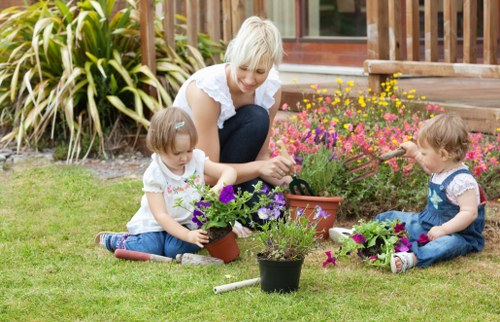 Gardener pruning a shrub in a well-maintained garden